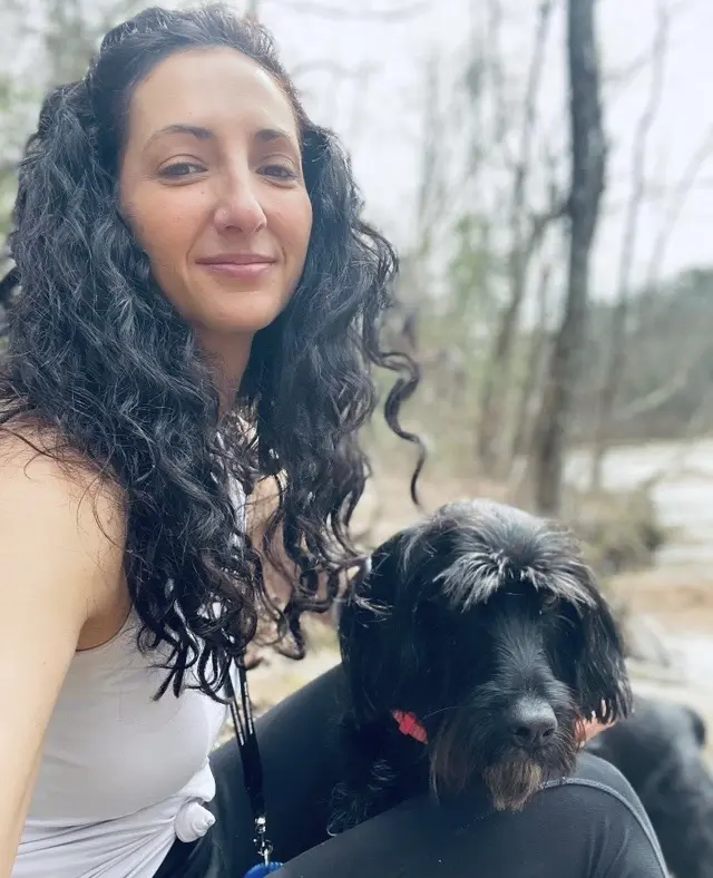 Woman with dog in outdoor setting.