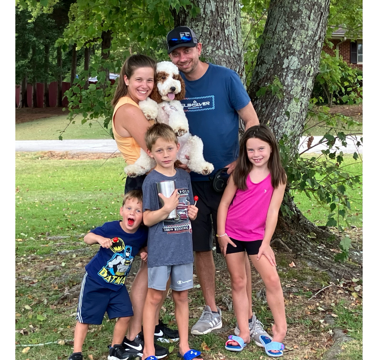 Family of five with dog under tree