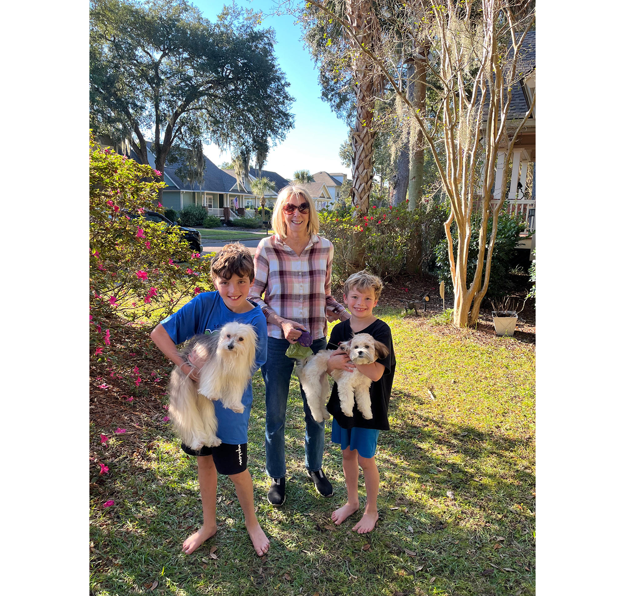 Woman with two boys holding small dogs