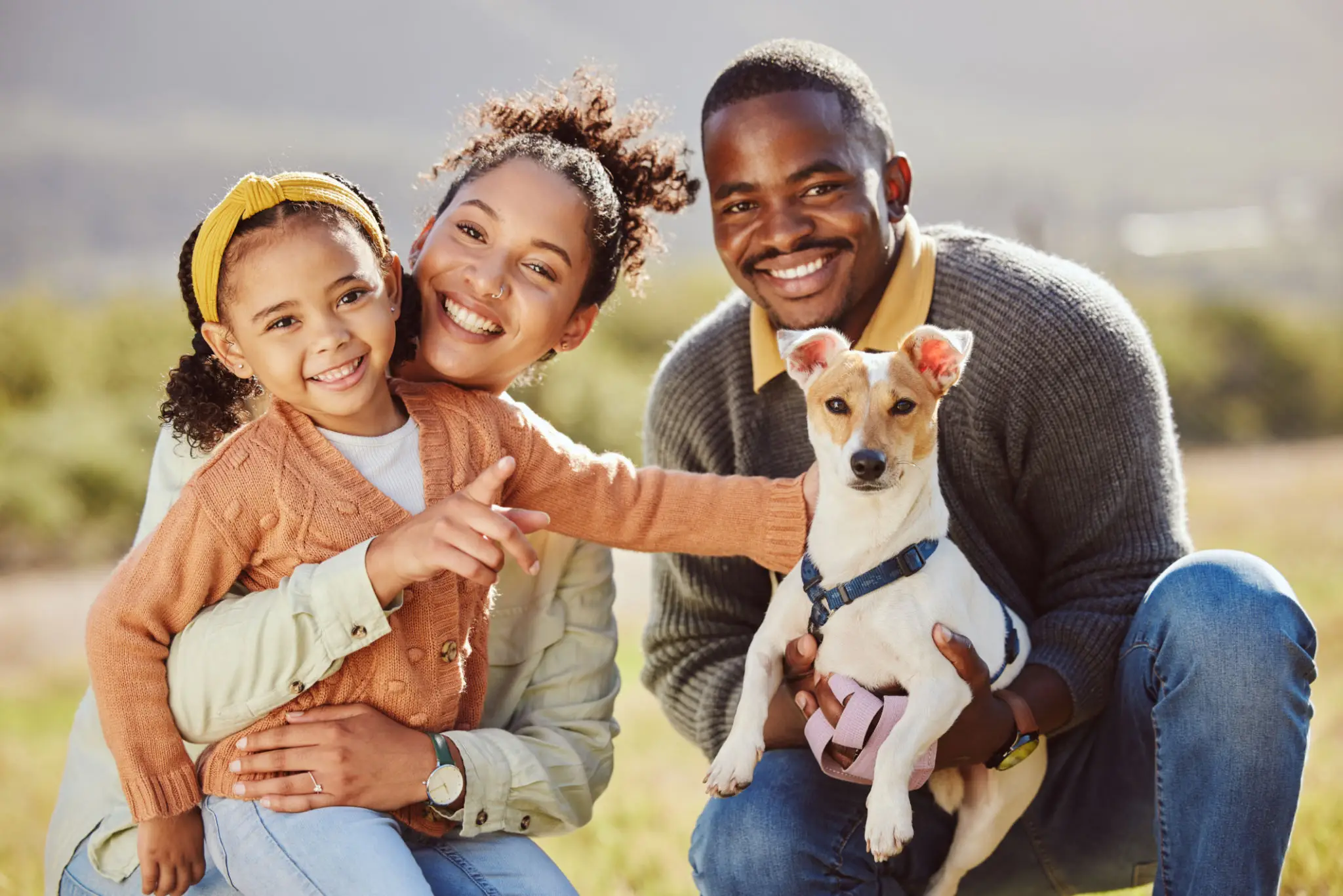 Smiling family of three with small dog